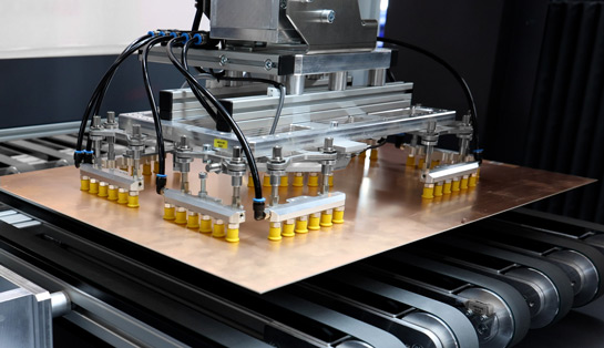 Mit Vakuumgreifern werden die Platinen in der Beladeanlage gehandhabt.